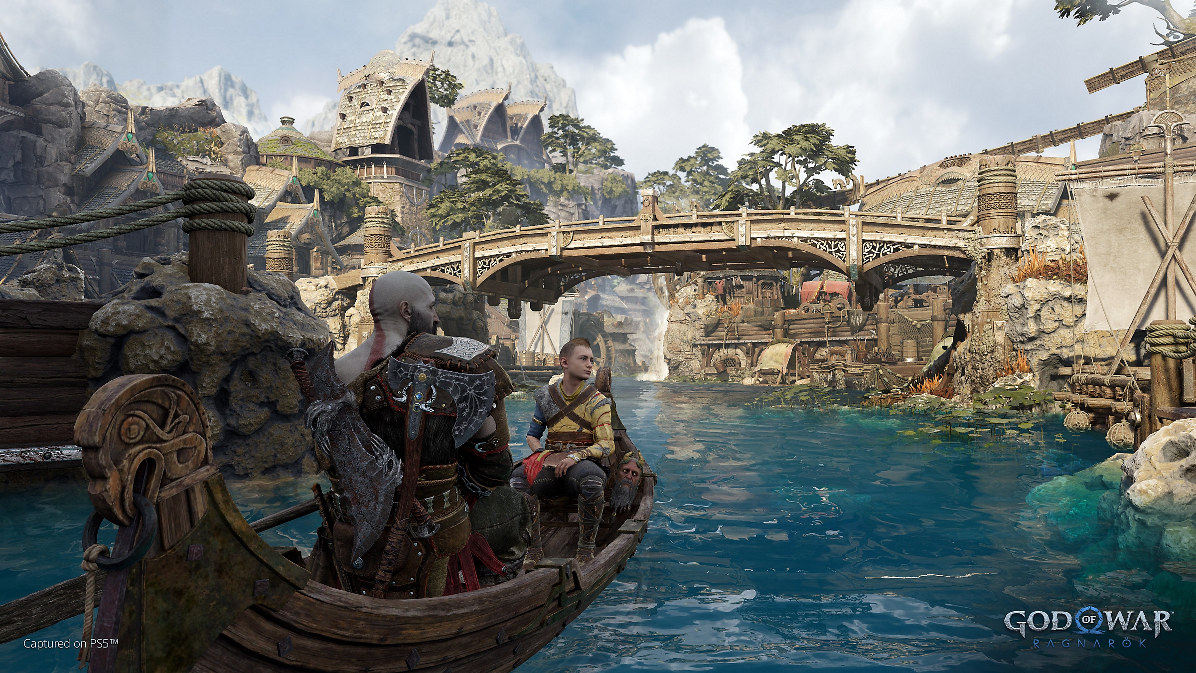 Kratos y Atreus en una barca navegando por una de las ciudades